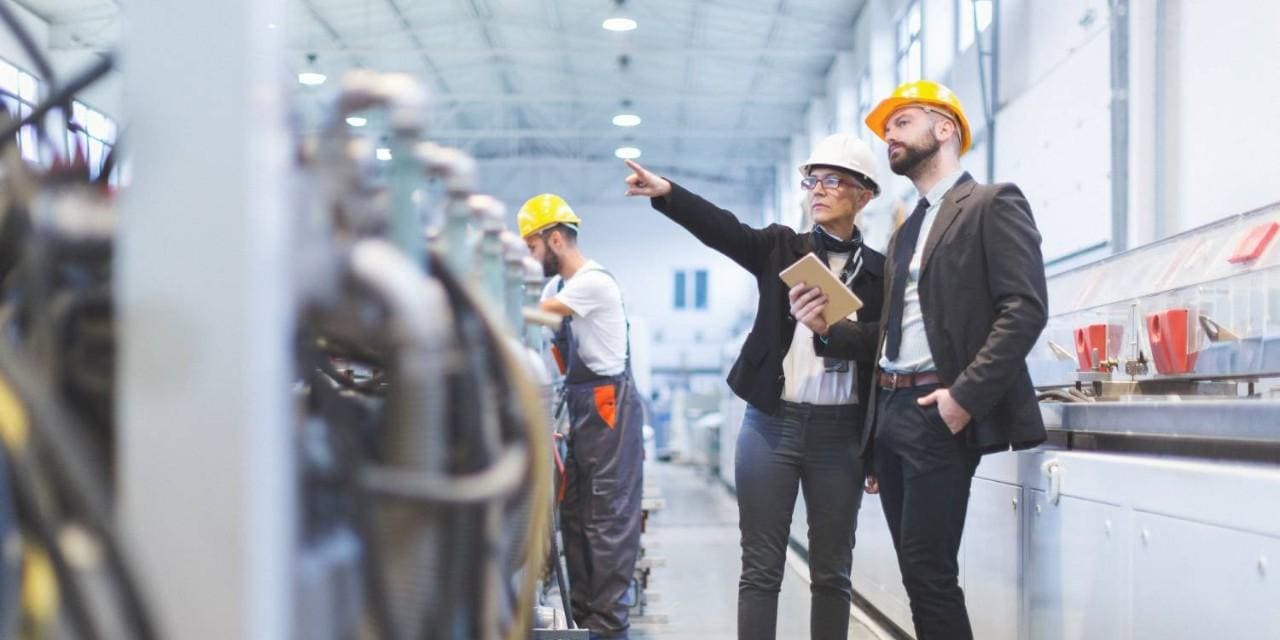 Quality inspectors pointing at machinery