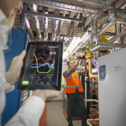 Workers using tablet in boiler room