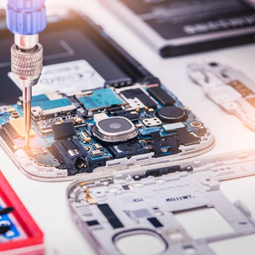 Close up of smart phone being assembled with screw driver