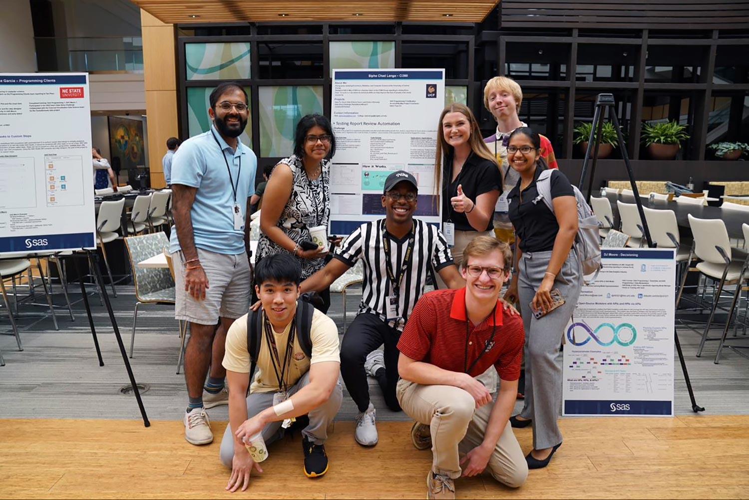 Student Intern Expo Group of diverse interns smiling in front of presentations at a student expo